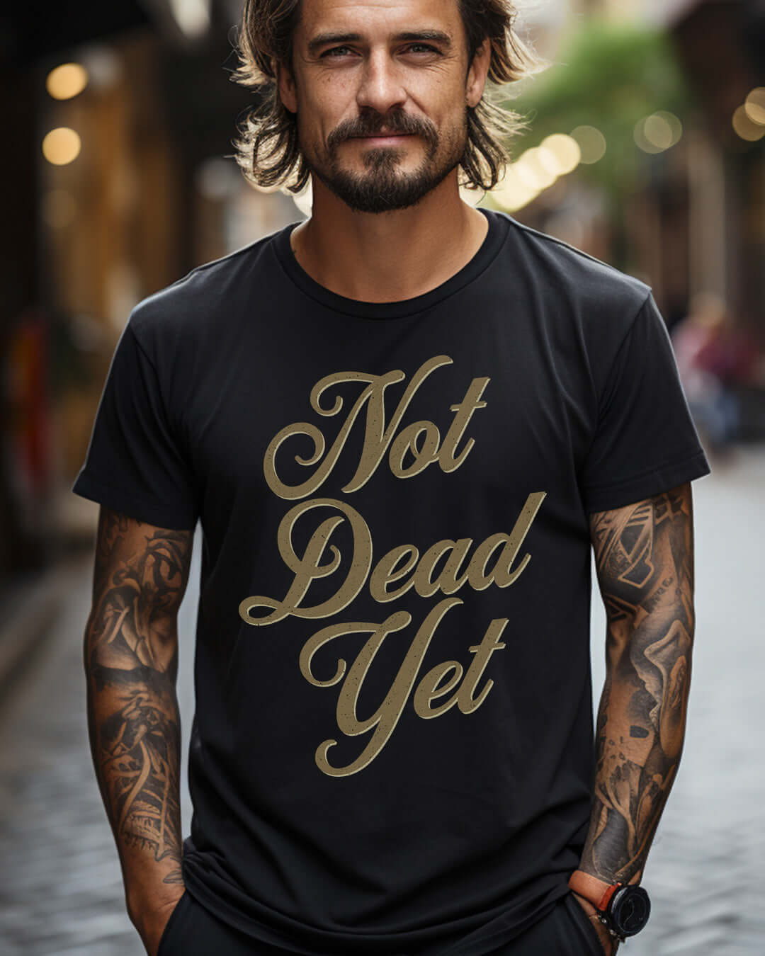 Man wearing "Not Dead Yet" motorcycle t-shirt, showcasing retro style and attitude in a vibrant street setting.