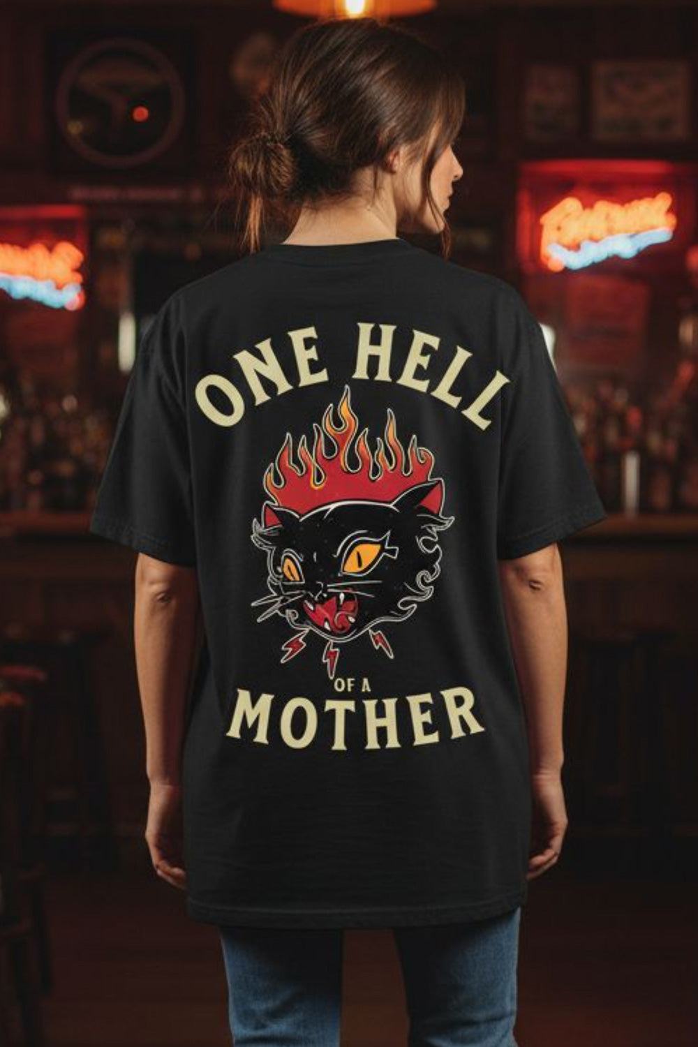 Person wearing a black t-shirt with a graphic design and text in a bar setting