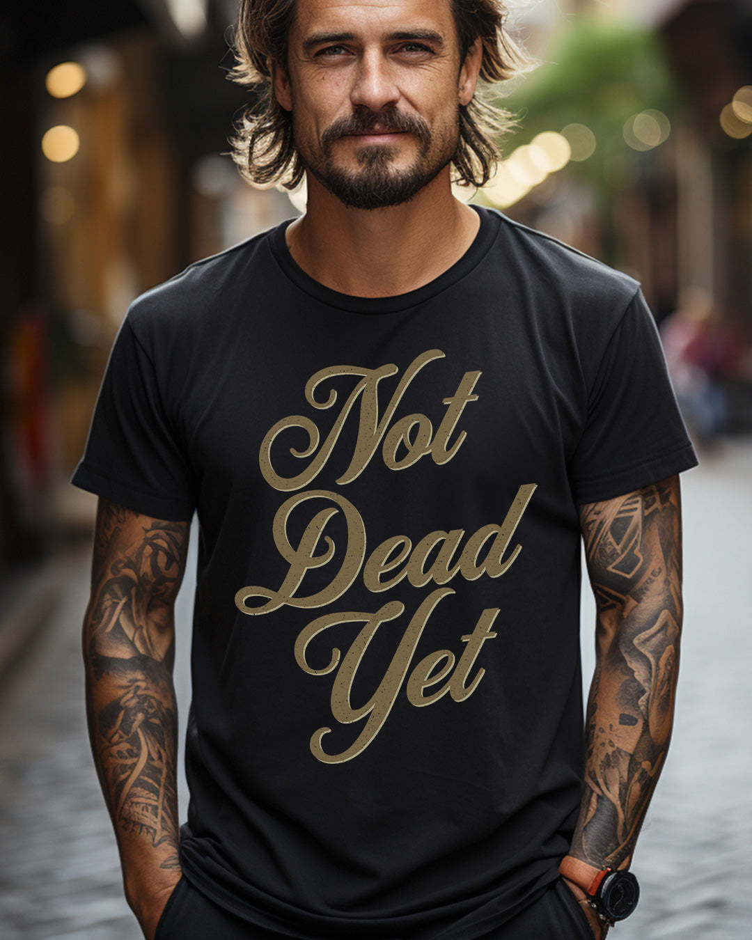 "Not Dead Yet motorcycle t-shirt with vintage style worn by tattooed man, embodying rebellious biker spirit on urban street"